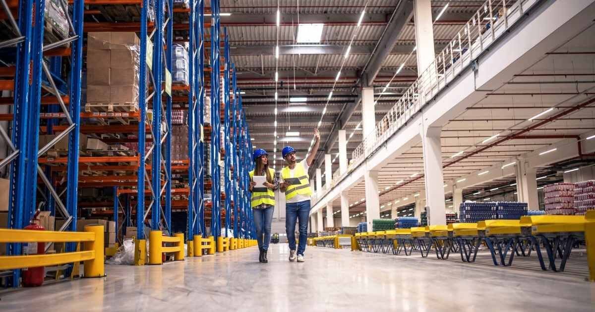 two workers walking through warehouse 